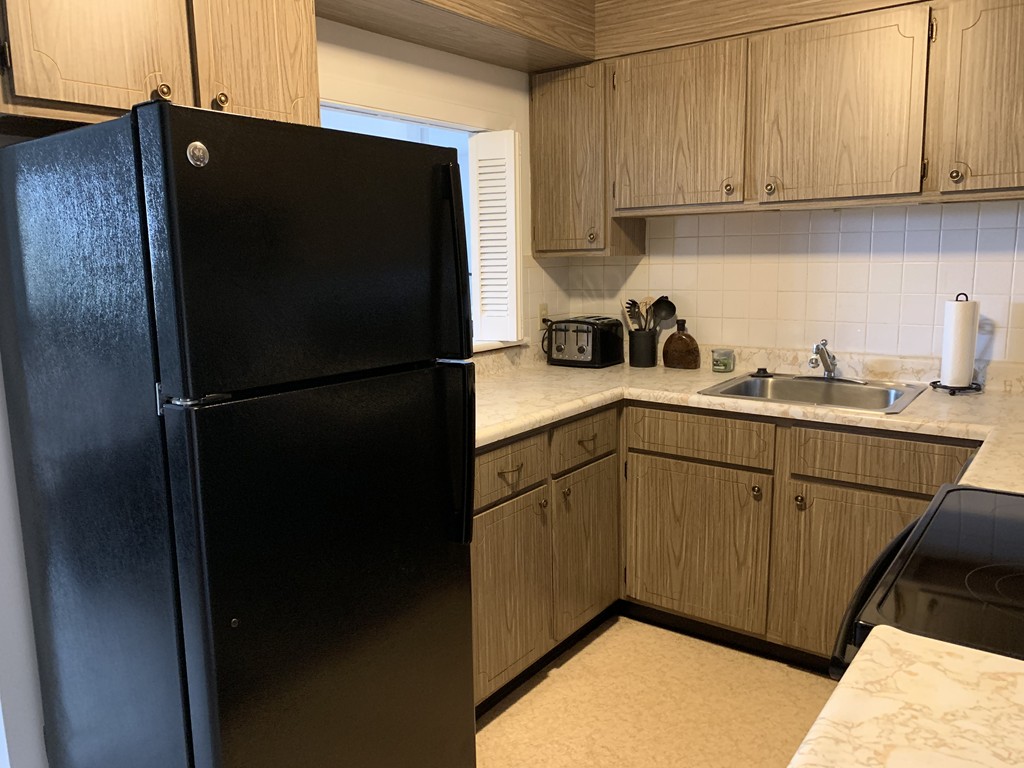 64 Jacqueline Road, Unit 12 Waltham, MA 02452 - Photo 8 of 16 a kitchen with a refrigerator and cabinets