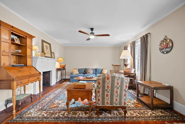 a work room with furniture a rug and a window