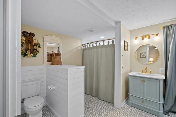 a spacious bathroom with a toilet sink vanity and mirror