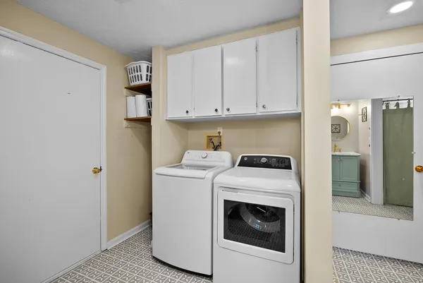 an empty room with wooden floor cabinet and windows