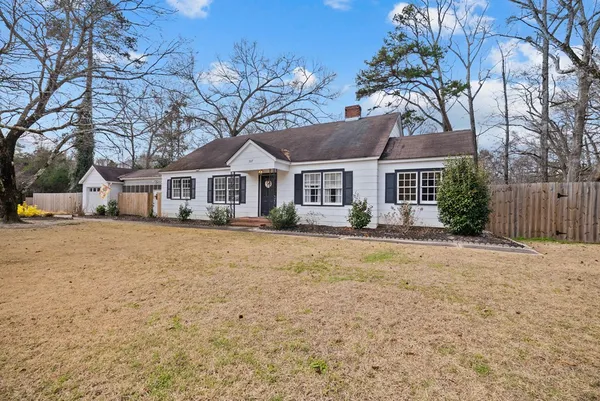 a front view of house with yard and trees around