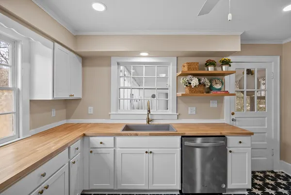a kitchen with stainless steel appliances granite countertop a sink and cabinets with wooden floor