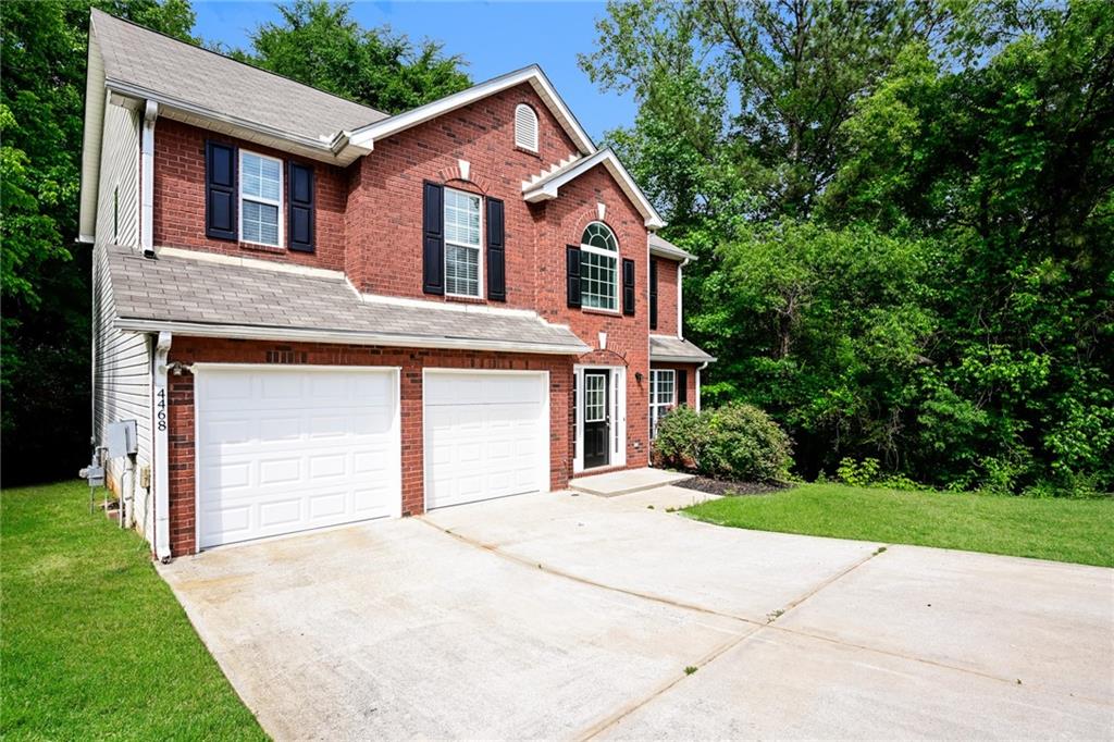 4468 Abram Way Conley, GA 30288 - Photo 2 of 23 a front view of a house with a yard and garage