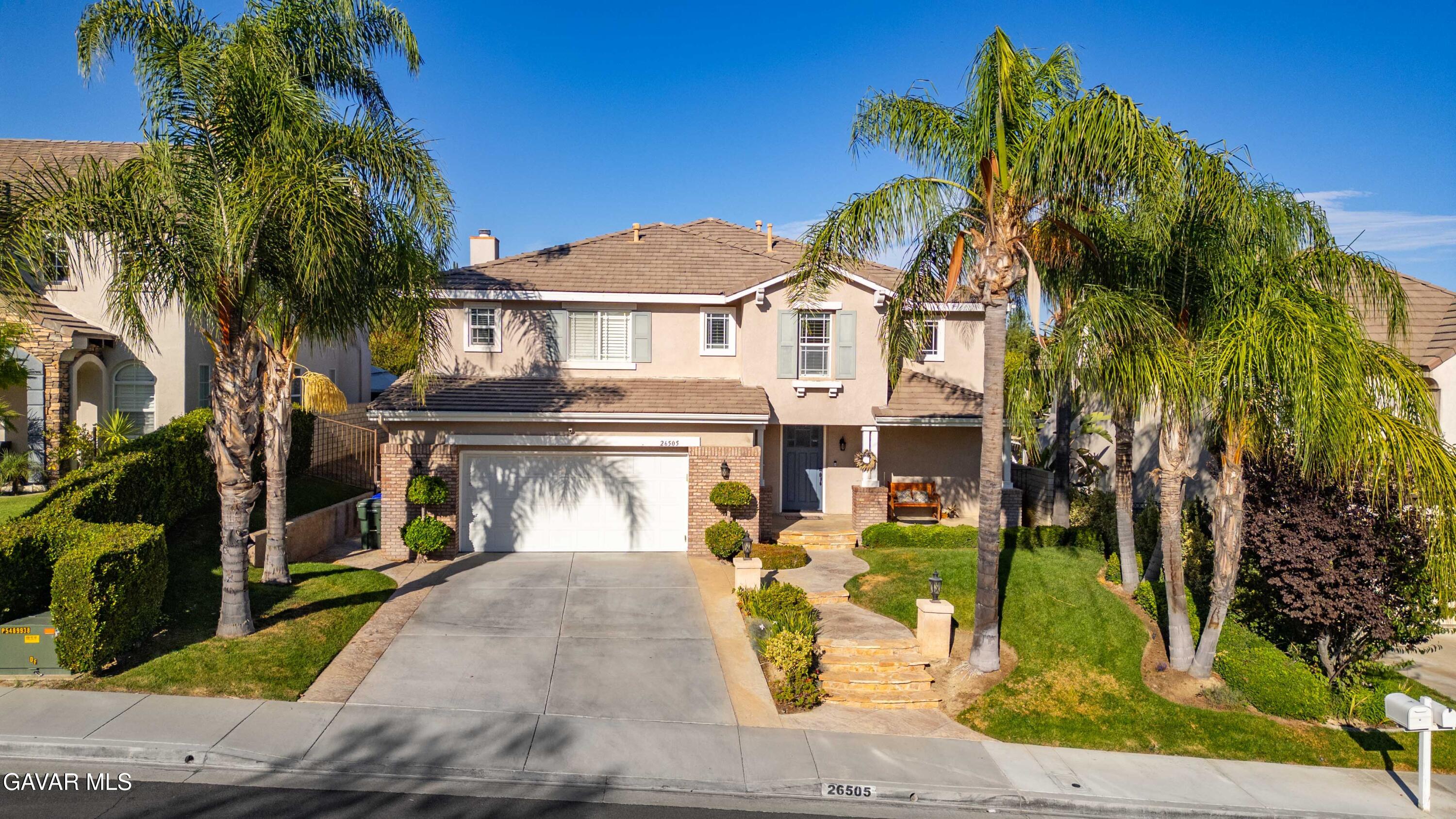 26505 Thackery Lane Stevenson Ranch, CA 91381 - Photo 2 of 63 a front view of a house with a garden