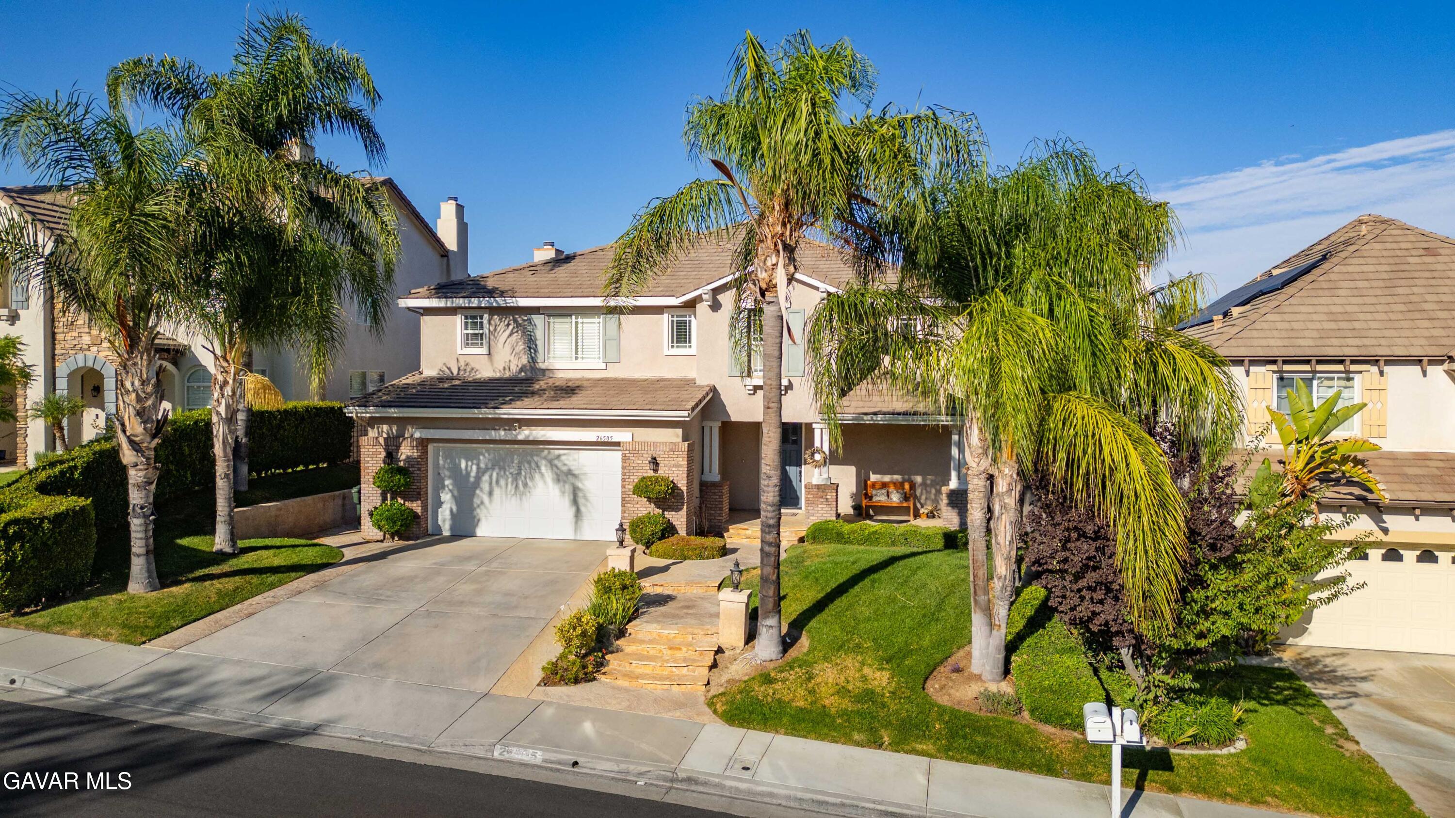 26505 Thackery Lane Stevenson Ranch, CA 91381 - Photo 3 of 63 a view of a white house with a yard and potted plants