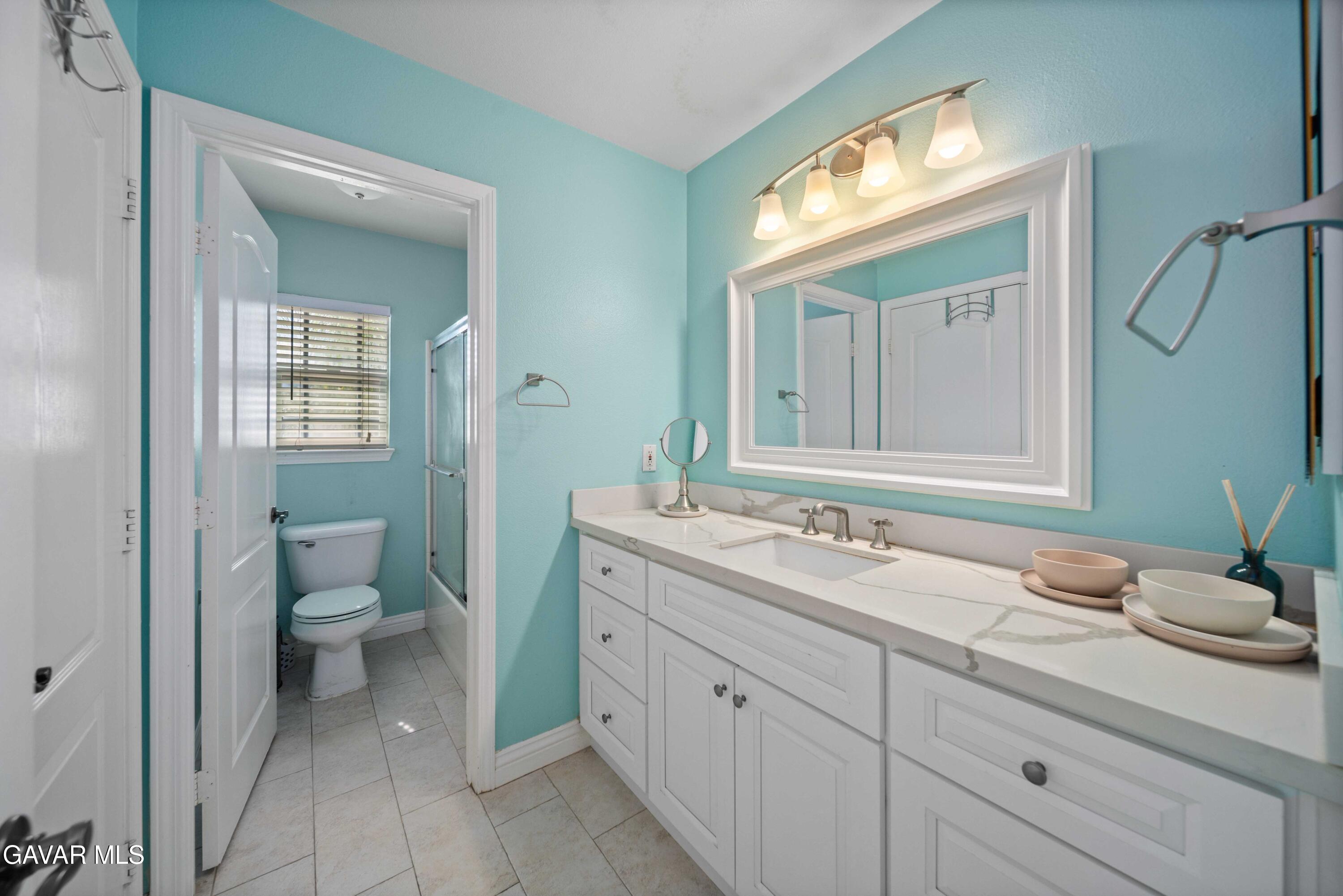 26505 Thackery Lane Stevenson Ranch, CA 91381 - Photo 41 of 63 a bathroom with a granite countertop sink toilet and mirror