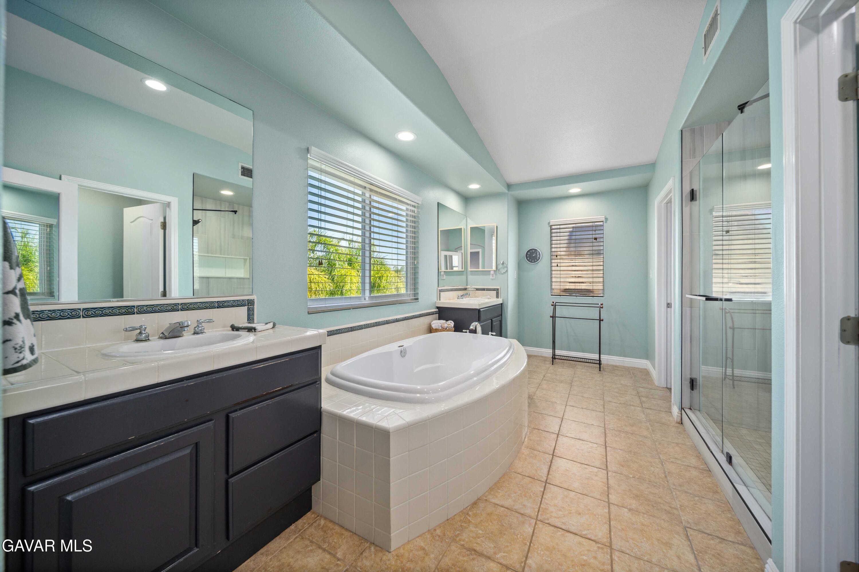 26505 Thackery Lane Stevenson Ranch, CA 91381 - Photo 52 of 63 a bathroom with a sink double vanity granite tub shower and a mirror