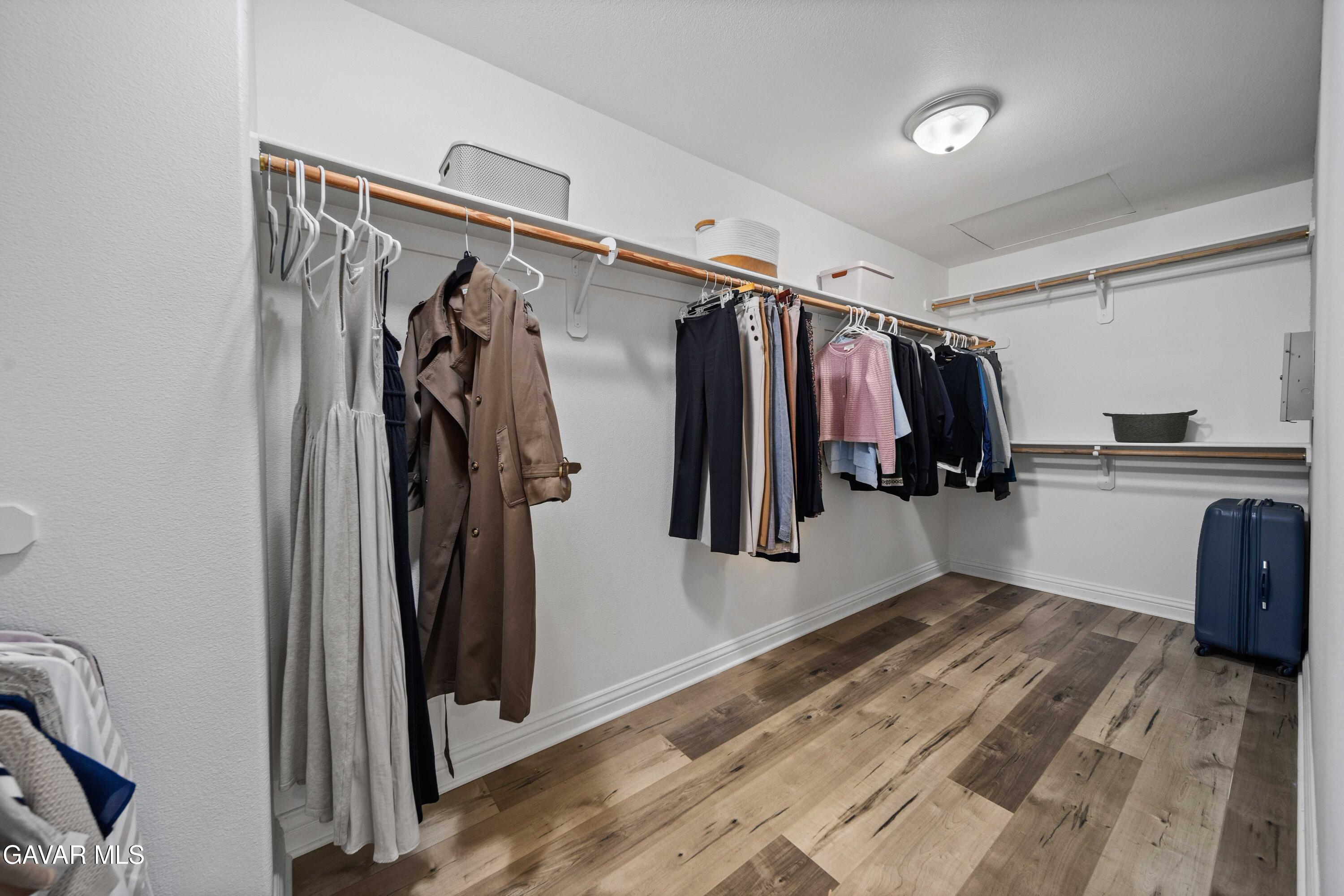 26505 Thackery Lane Stevenson Ranch, CA 91381 - Photo 55 of 63 a view of walk in closet with clothes and shoes