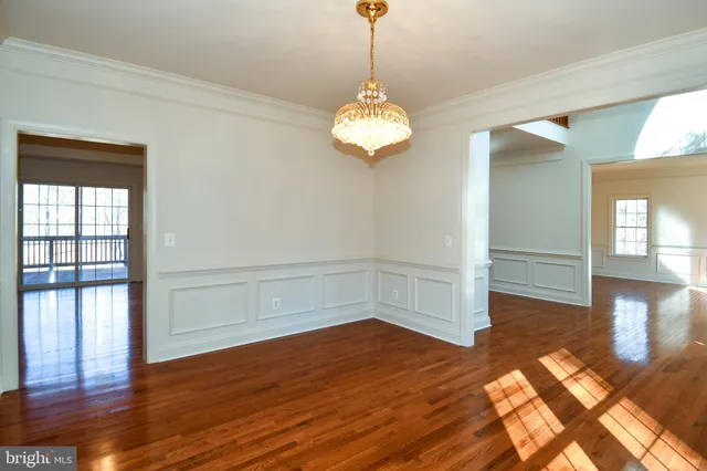 an empty room with wooden floor windows and fireplace