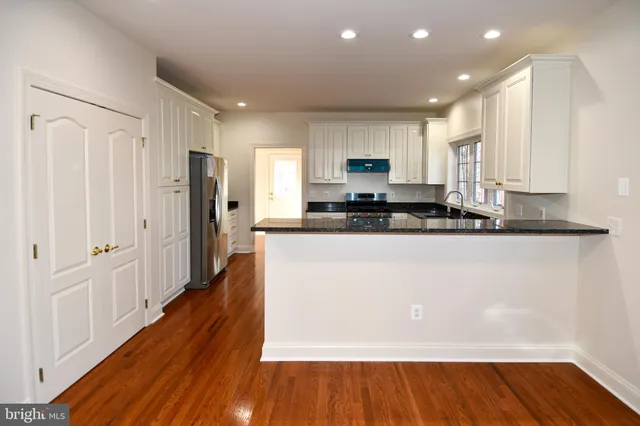 a view of an empty room with glass door and wooden floor