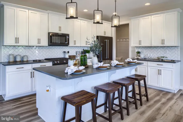 a kitchen with stainless steel appliances kitchen island granite countertop a table chairs microwave and sink