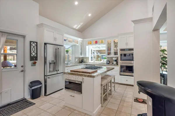 a kitchen with stainless steel appliances granite countertop a stove and a refrigerator