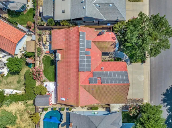 an aerial view of residential houses with outdoor space and trees