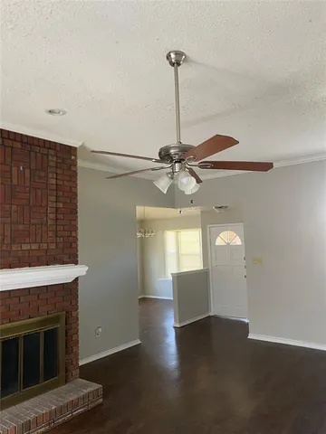a view of an empty room with a fireplace and a window