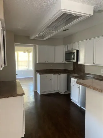 a kitchen with kitchen island granite countertop a stove top oven a sink a counter space and cabinets