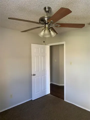 an empty room with a fan and a fan