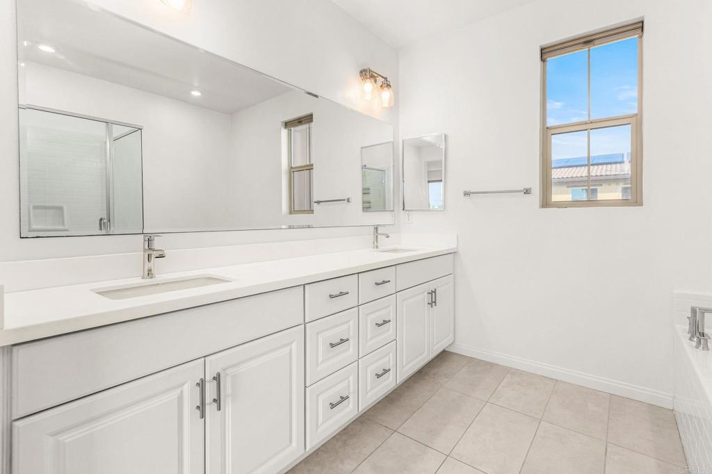 1609 Holly Leaf Way Oceanside, CA 92056 - Photo 14 of 26 a bathroom with double sink and a mirror
