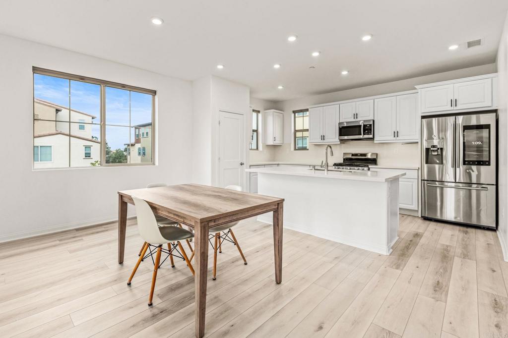 1609 Holly Leaf Way Oceanside, CA 92056 - Photo 3 of 26 a kitchen with kitchen island a stove a sink a refrigerator and a microwave