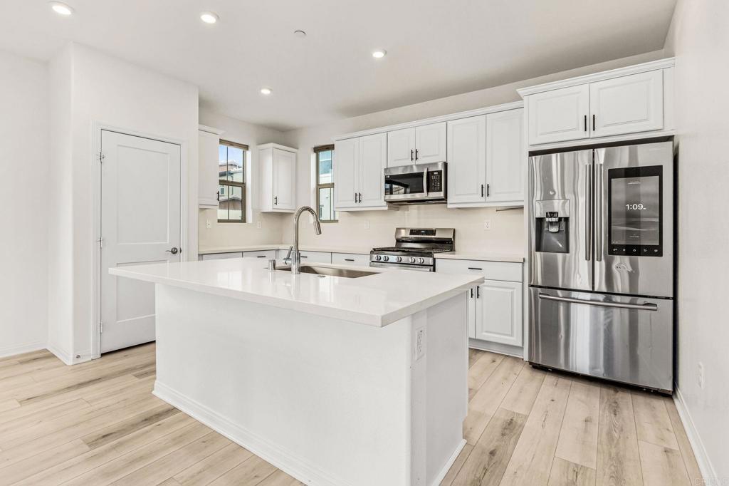 1609 Holly Leaf Way Oceanside, CA 92056 - Photo 5 of 26 a kitchen with stainless steel appliances a refrigerator stove microwave and cabinets