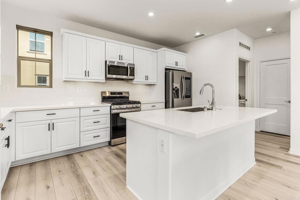 1609 Holly Leaf Way Oceanside, CA 92056 - Photo 6 of 26 a kitchen with stainless steel appliances a sink stove and cabinets