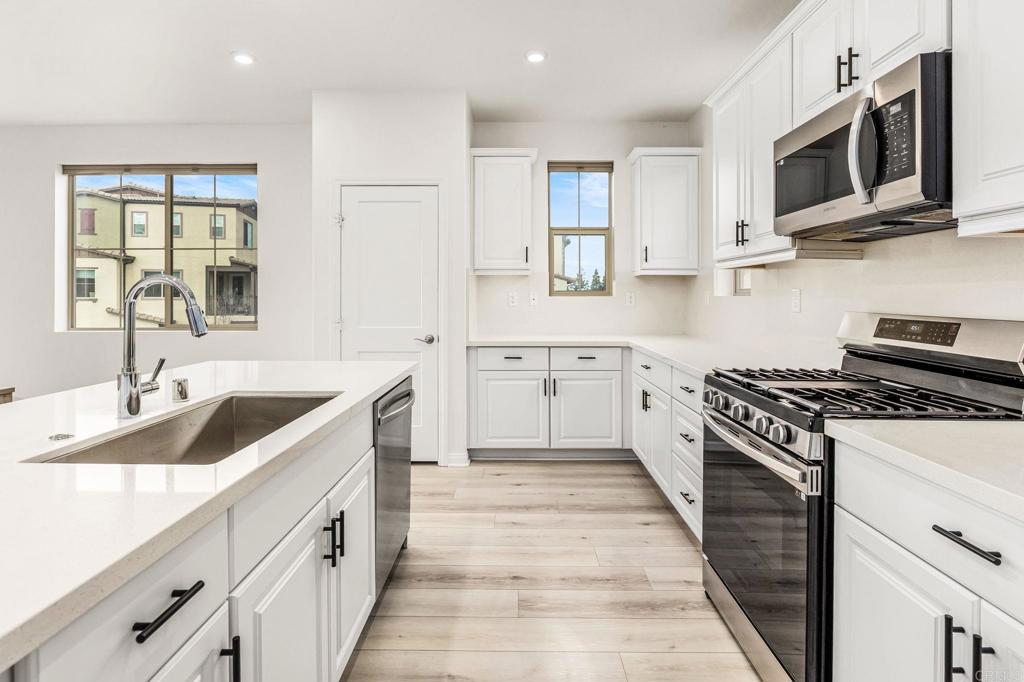 1609 Holly Leaf Way Oceanside, CA 92056 - Photo 7 of 26 a kitchen with stainless steel appliances granite countertop a sink and stove top oven