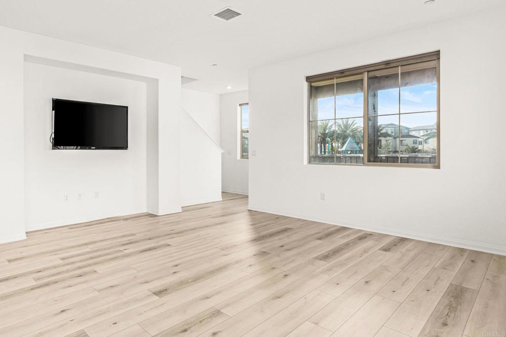 1609 Holly Leaf Way Oceanside, CA 92056 - Photo 9 of 26 an empty room with wooden floor and windows