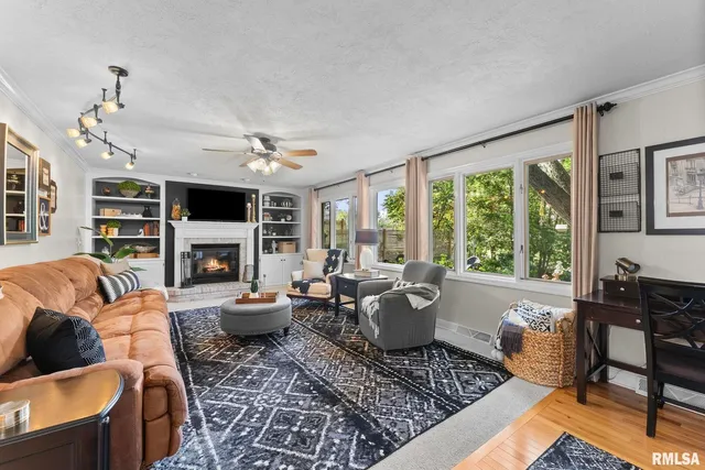 a living room with furniture fireplace and a large window