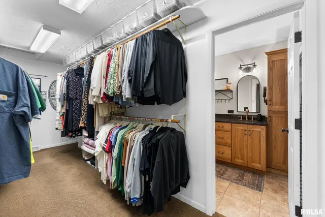 a view of walk in closet with clothes and shoes