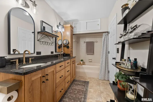 a bathroom with a granite countertop double vanity sink and a mirror
