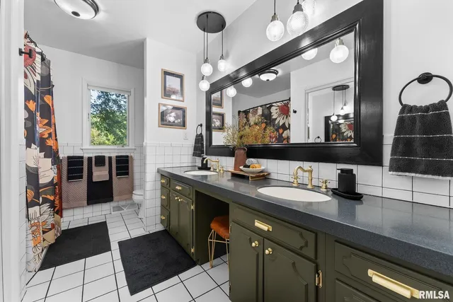 a bathroom with double vanity and a mirror