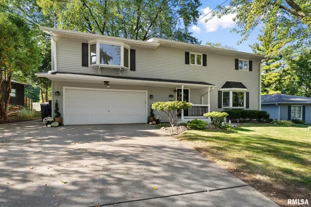 a view of a house with backyard and trees
