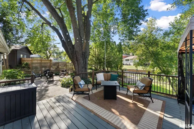 a balcony with wooden floor table and chairs