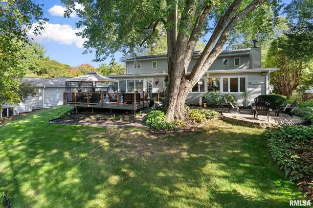 a front view of a house with a garden and trees