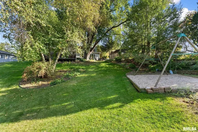 a view of a backyard with plants and a bench