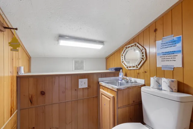 a bathroom with a granite countertop sink mirror vanity and toilet