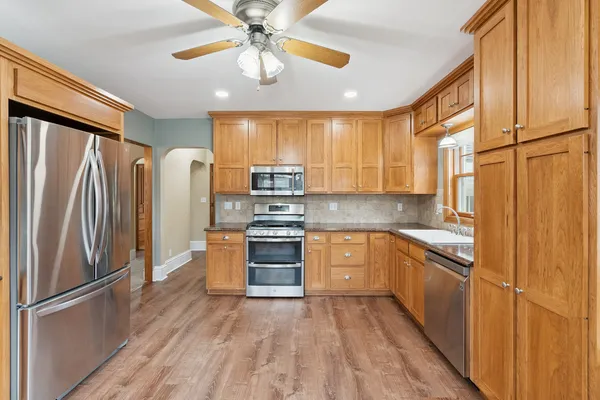 a kitchen with stainless steel appliances granite countertop a refrigerator a stove top oven a sink and dishwasher