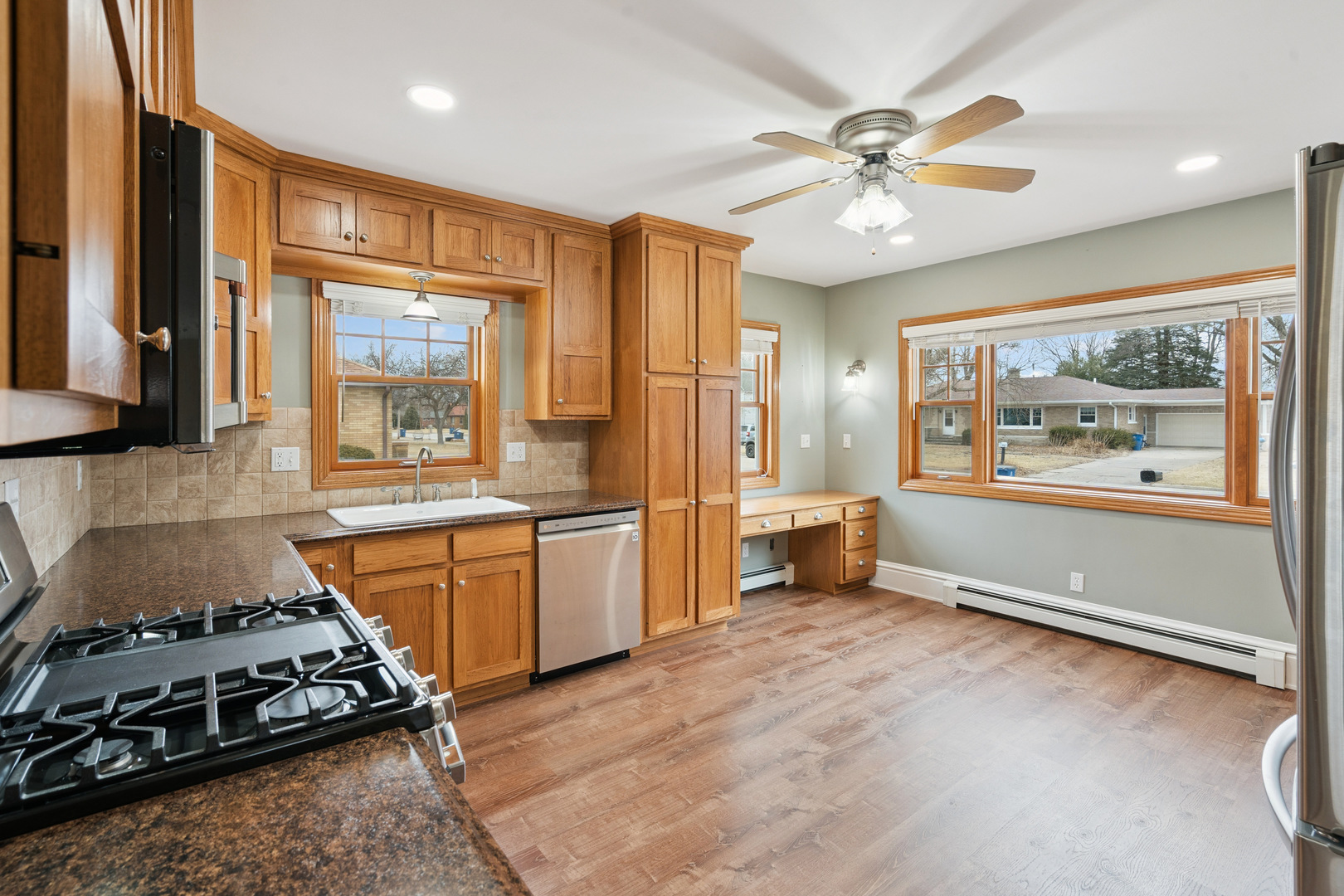 1416 6th Street Orion, IL 61273 - Photo 10 of 48 a large kitchen with stainless steel appliances a stove a refrigerator a sink a dining table and chairs with wooden floor