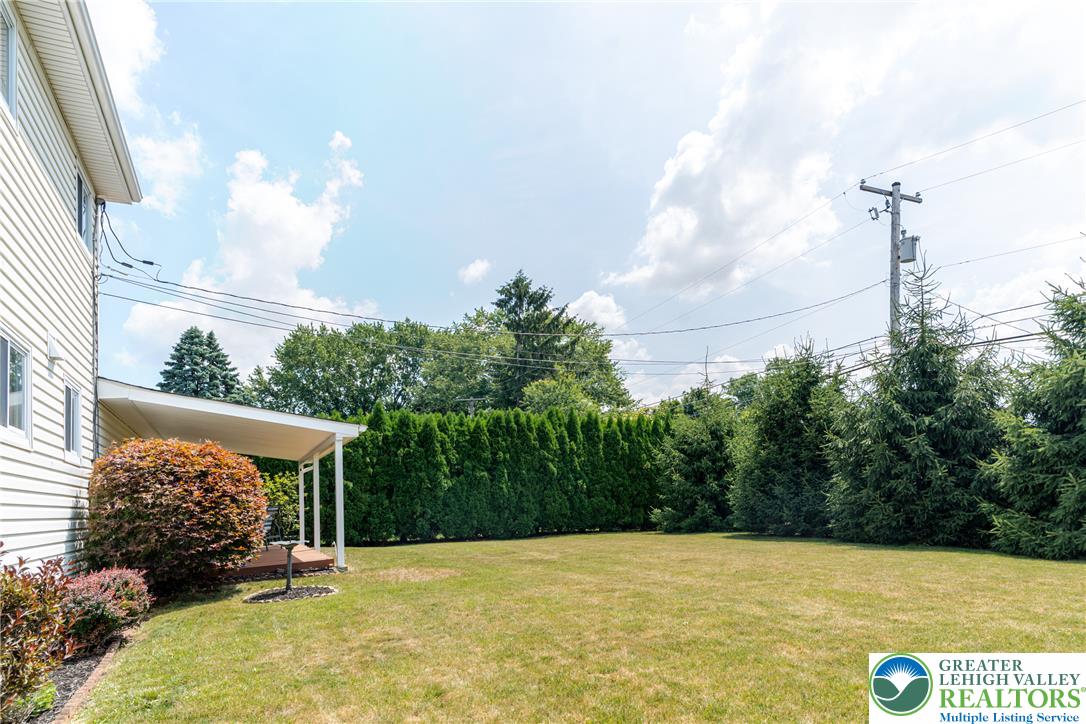 2130 Wisteria Road Lower Macungie Township, PA 18062 - Photo 46 of 48 A deep green hedge borders a squared off and flat yard, offering privacy for the covered deck.