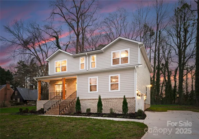 a front view of a house with a garden and plants