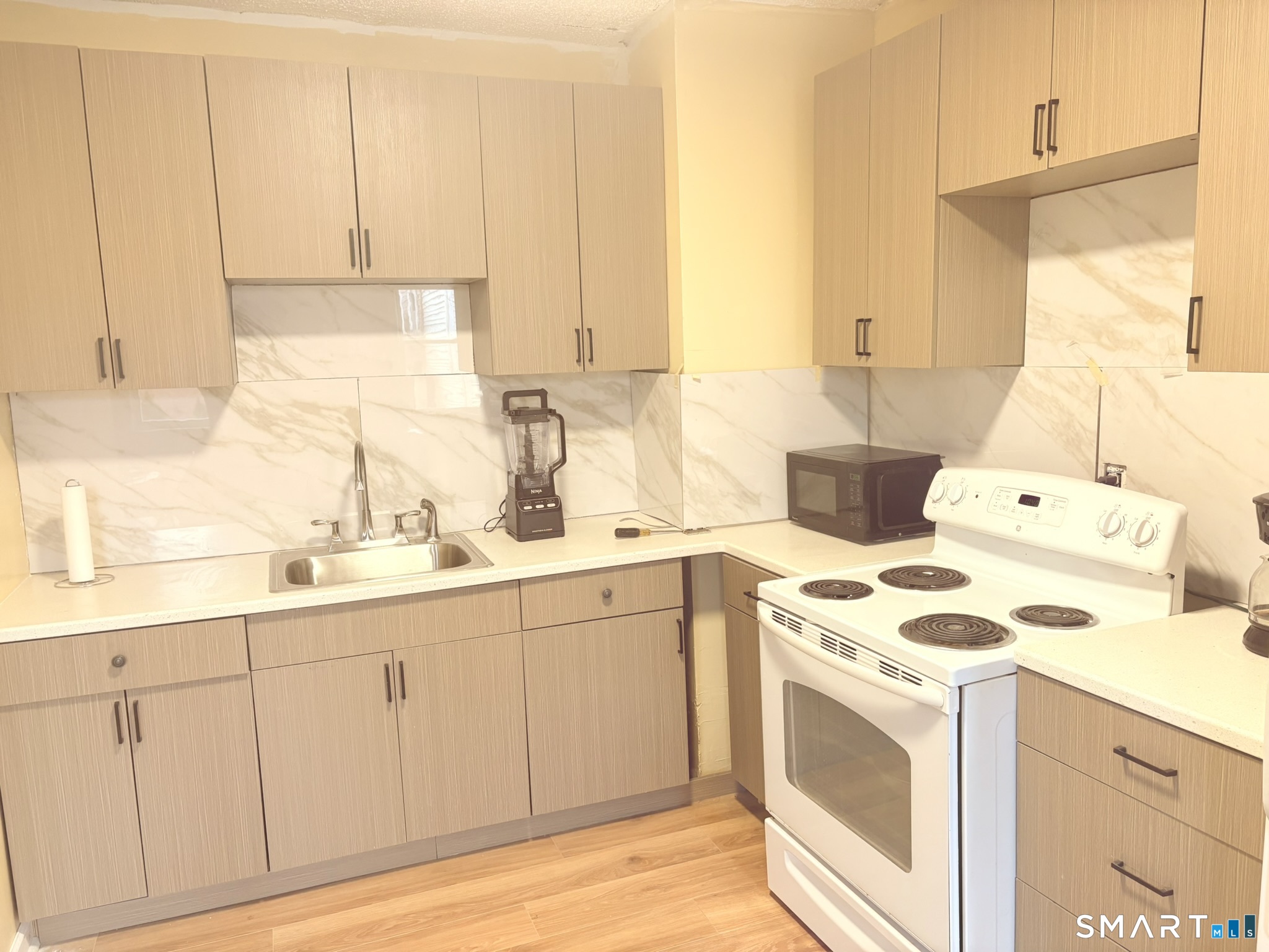 a kitchen with granite countertop white cabinets sink and white appliances