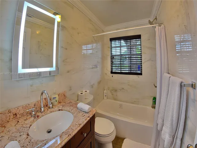 a bathroom with a granite countertop sink toilet tub and shower