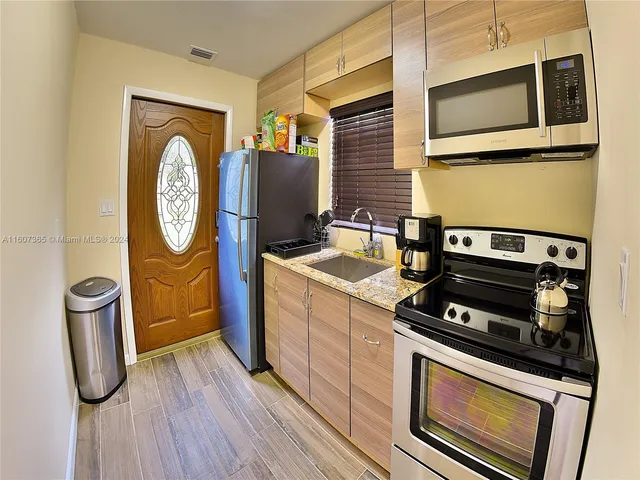 a kitchen with stainless steel appliances granite countertop a stove and a microwave