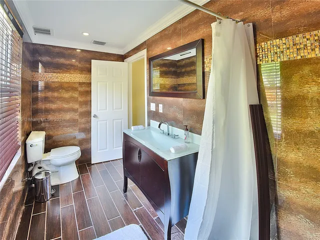 a bathroom with a sink mirror vanity and toilet