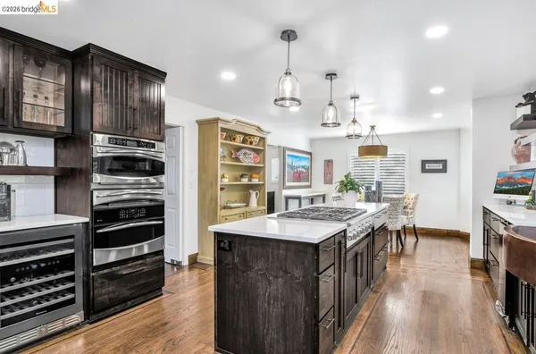 a room with stainless steel appliances granite countertop a sink a stove and a refrigerator