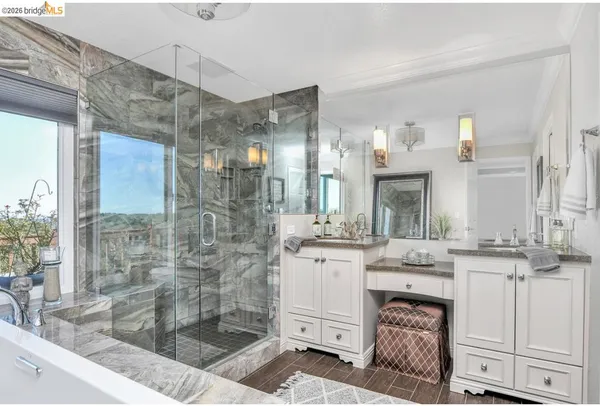 a spacious bathroom with a granite countertop sink a mirror and a shower