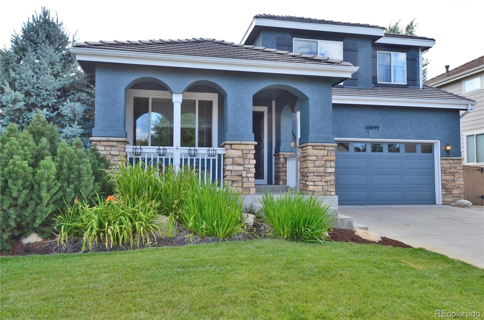 10699 Wynspire Way Highlands Ranch, CO 80130 - Photo 1 of 40 a front view of a house with a garden