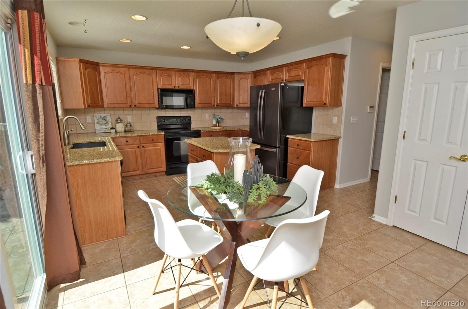 10699 Wynspire Way Highlands Ranch, CO 80130 - Photo 14 of 40 a view of a dining room with furniture a kitchen and chandelier