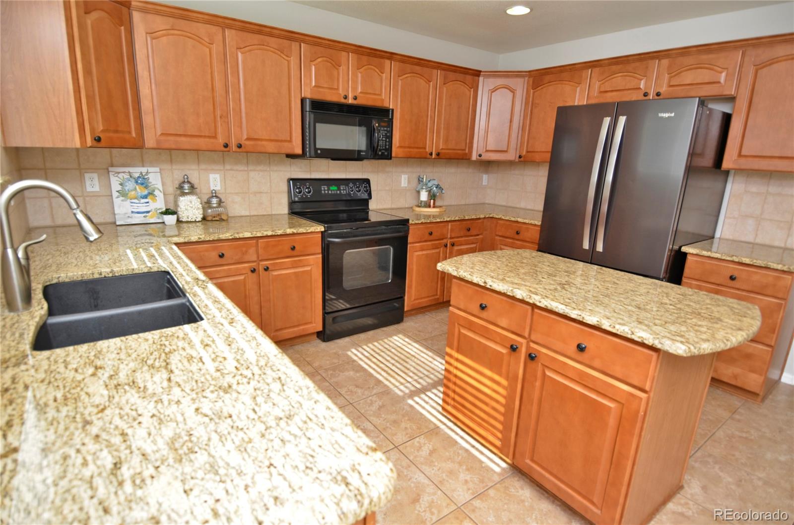 10699 Wynspire Way Highlands Ranch, CO 80130 - Photo 16 of 40 a kitchen with stainless steel appliances granite countertop a refrigerator stove microwave and sink