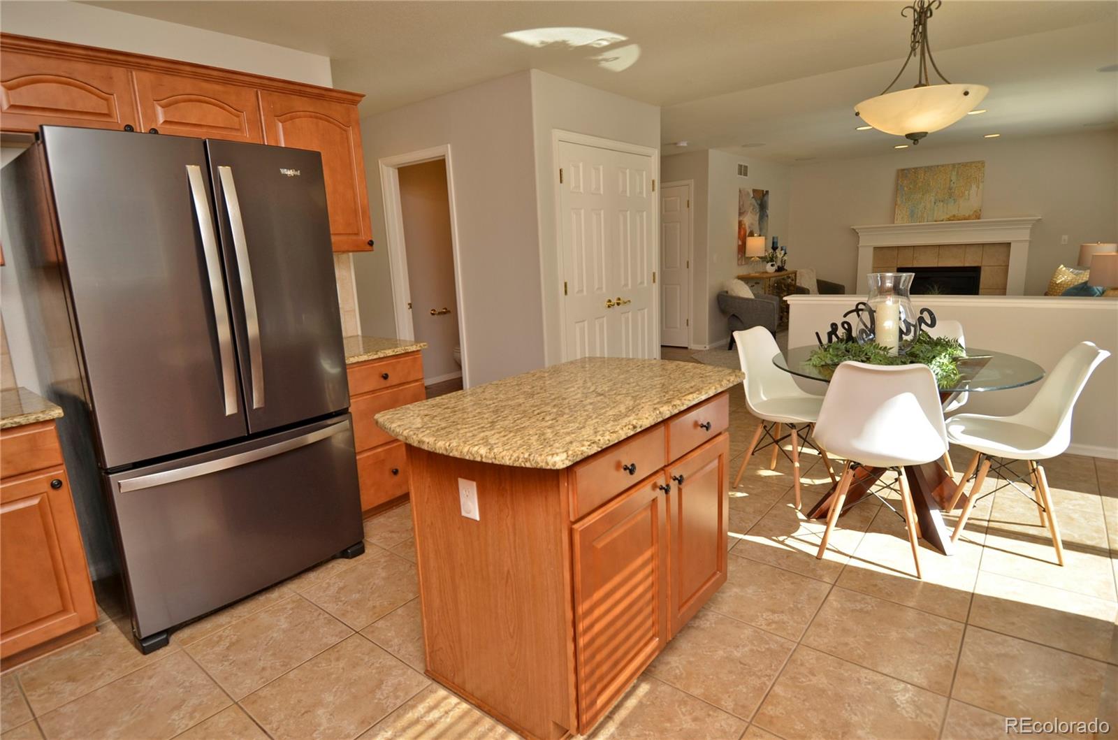 10699 Wynspire Way Highlands Ranch, CO 80130 - Photo 17 of 40 a kitchen with stainless steel appliances granite countertop a refrigerator a stove a sink a dining table and chairs
