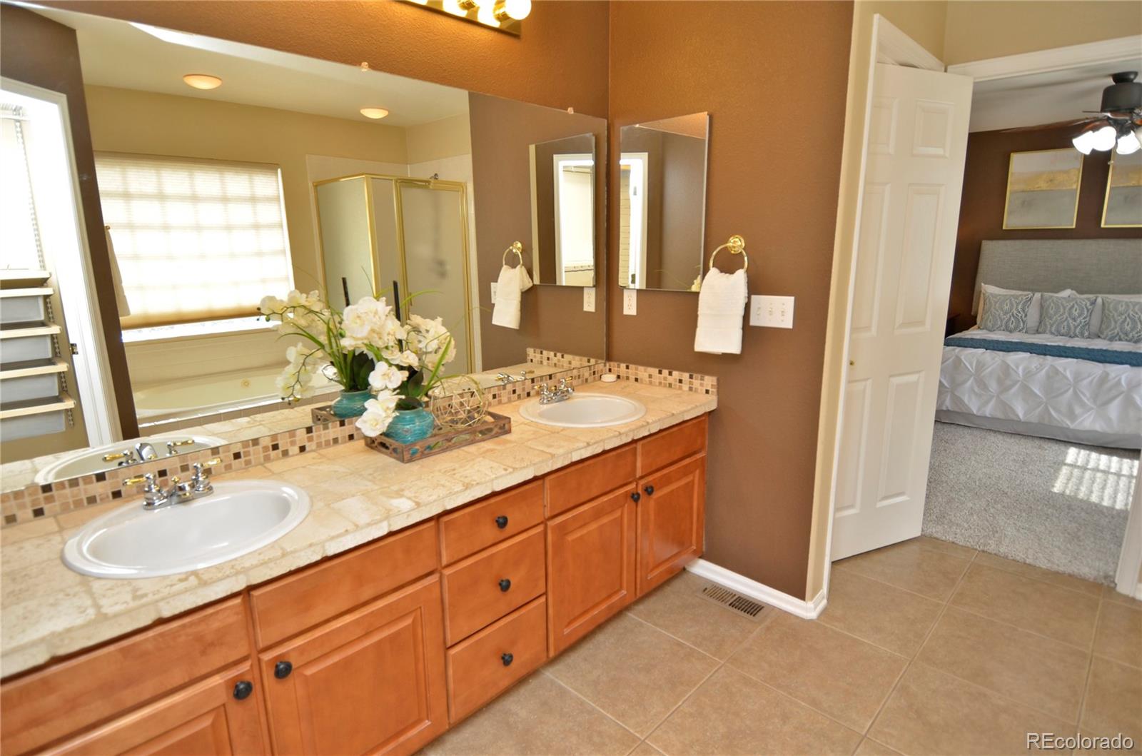 10699 Wynspire Way Highlands Ranch, CO 80130 - Photo 28 of 40 a bathroom with double vanity sink a mirror and a shower